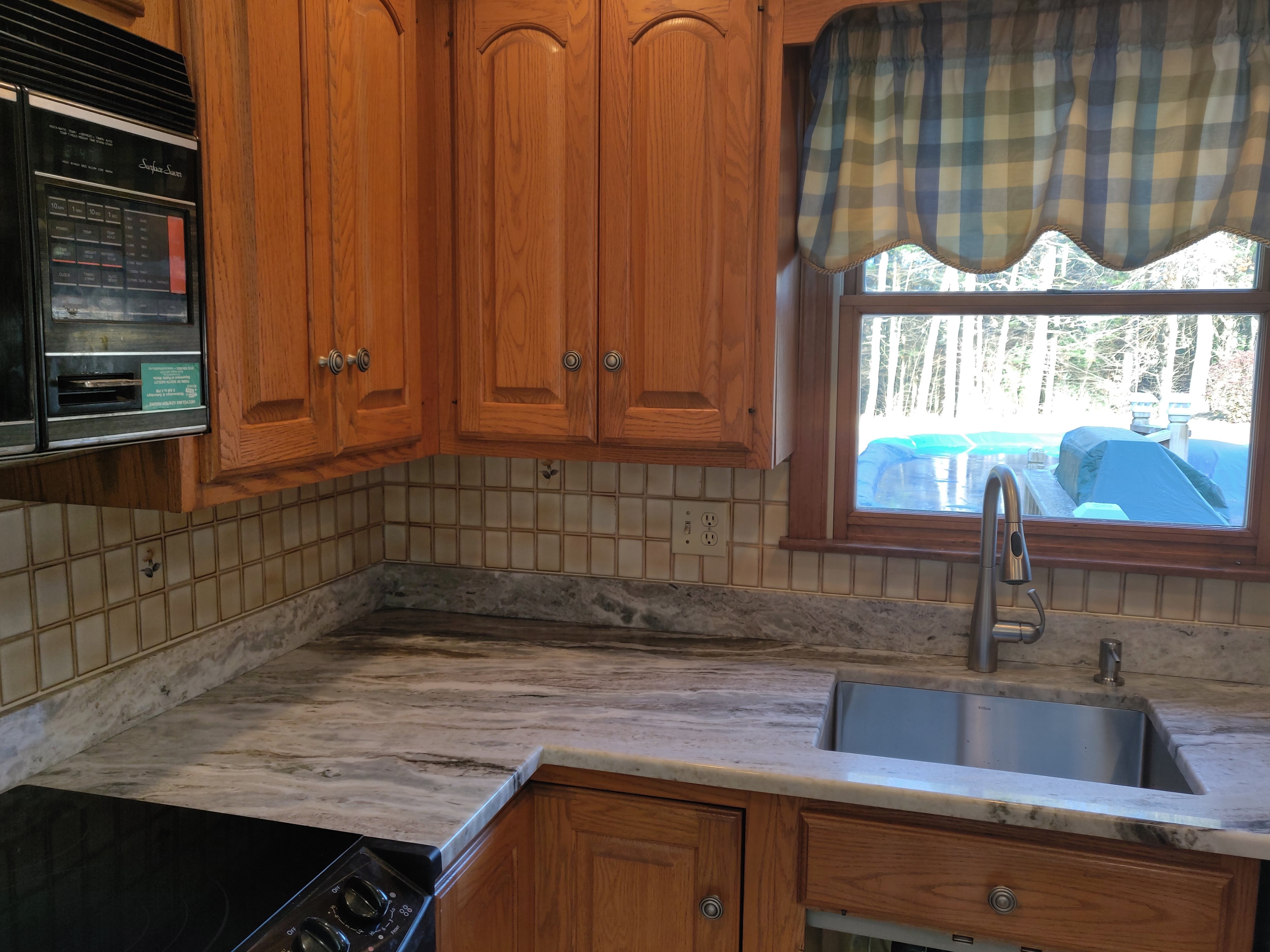 Granite countertop corner detail with oak cabinets